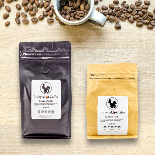 Two coffee packages from Bushytail Coffee on a wooden surface with coffee beans and a cup.