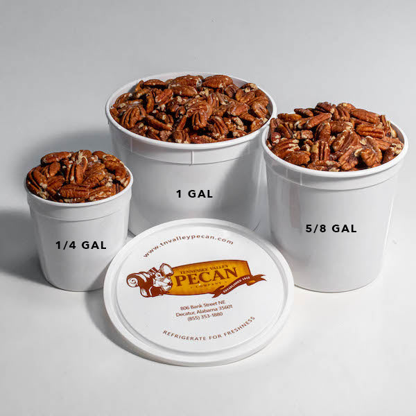 Three white buckets filled with pecans of different sizes on a gray background.