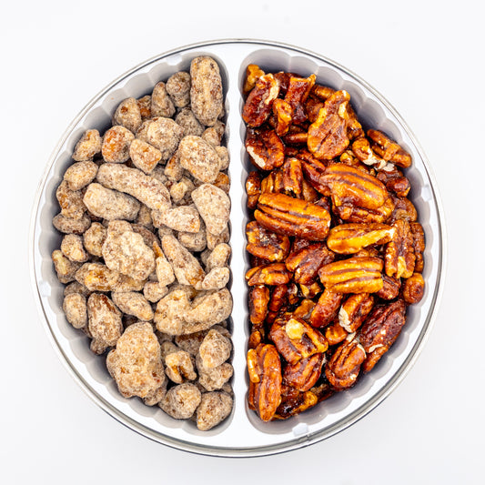 Praline and Honey Glazed pecans in a divided tin on white background.
