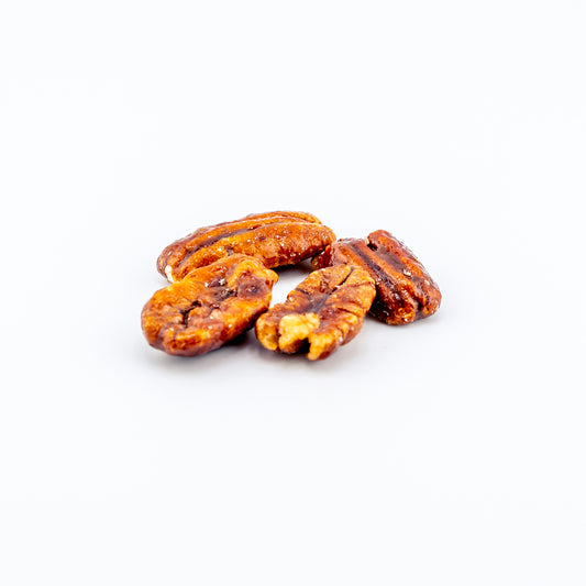Honey-glazed pecans on a white background