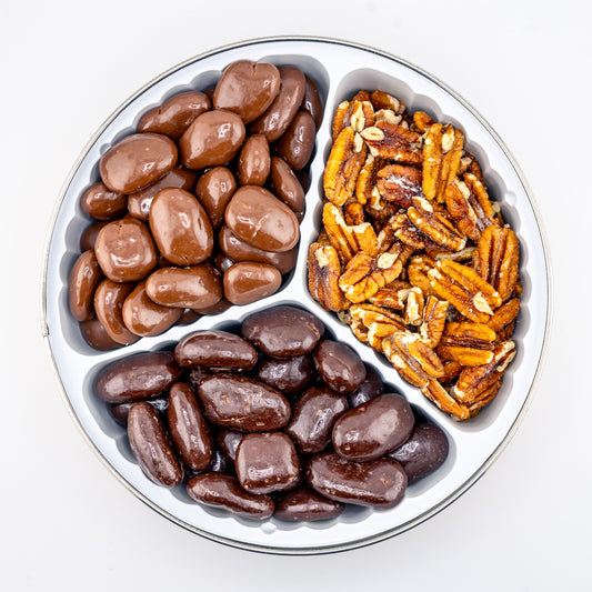 Milk Chocolate, Dark Chocolate, and toasted pecans in a divided tin on a white background