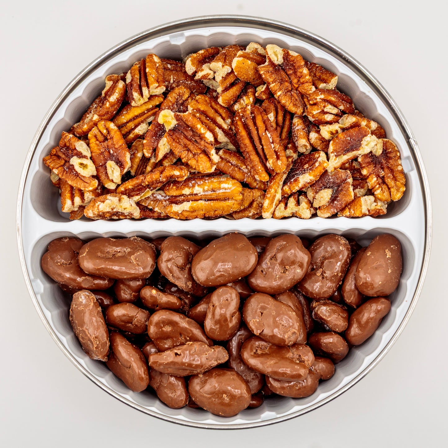 Toasted and Milk Chocolate Pecans in a gift tin on a white background