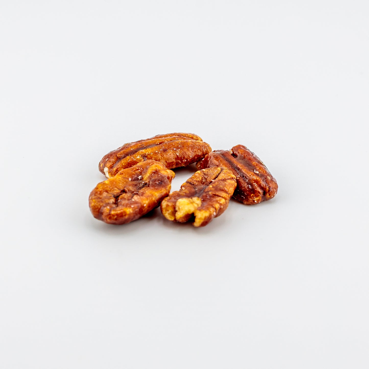 Honey glazed pecans on a white background