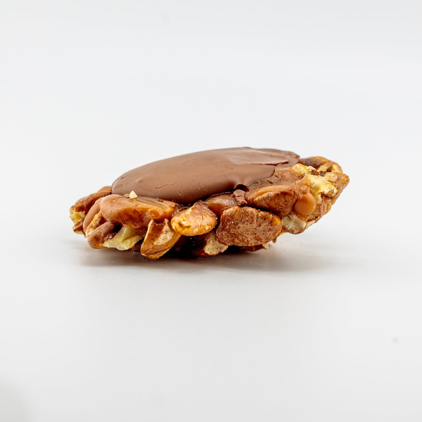 Pecan cluster laying on its side on a white background