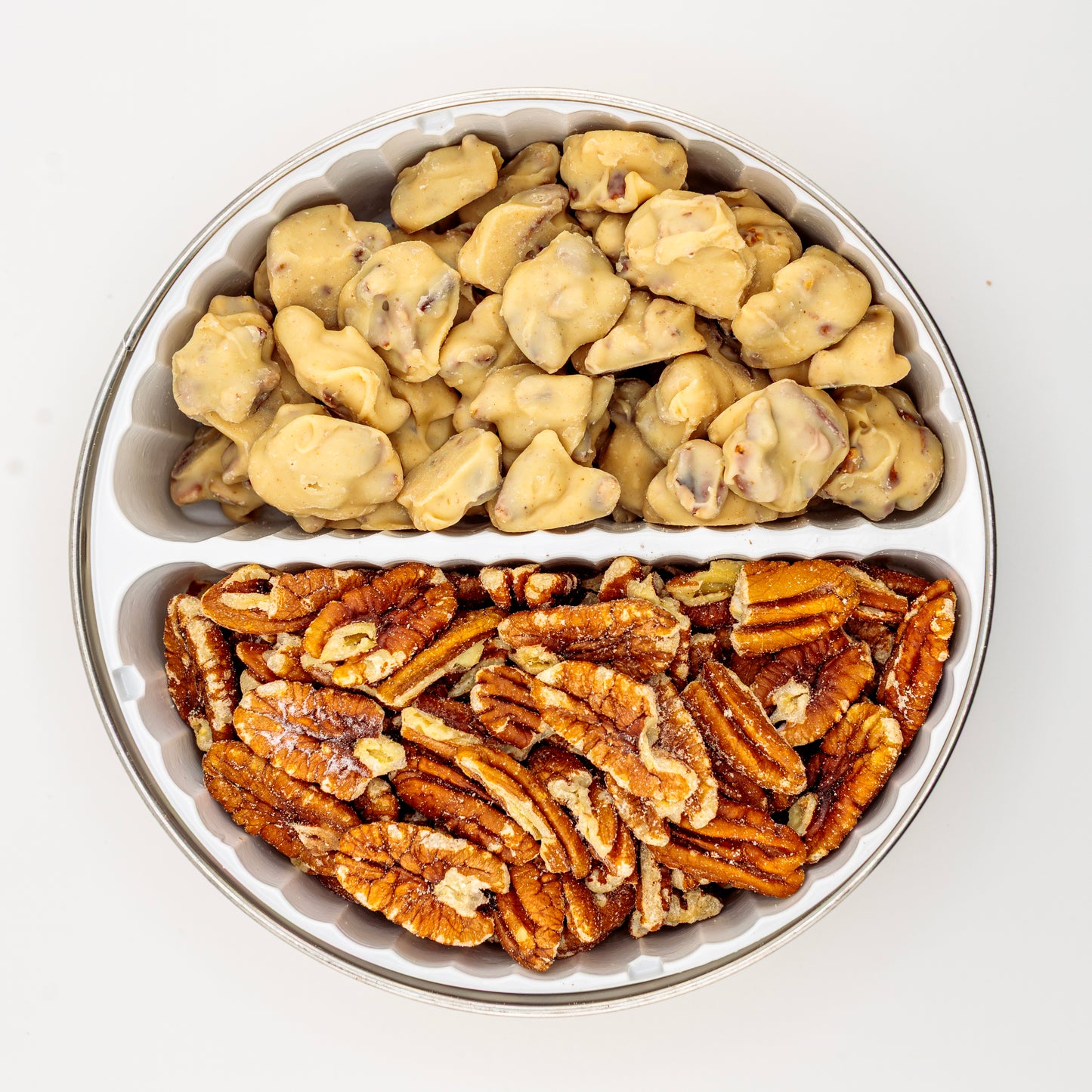Pecan drops and toasted pecans in a holiday tin on a white background