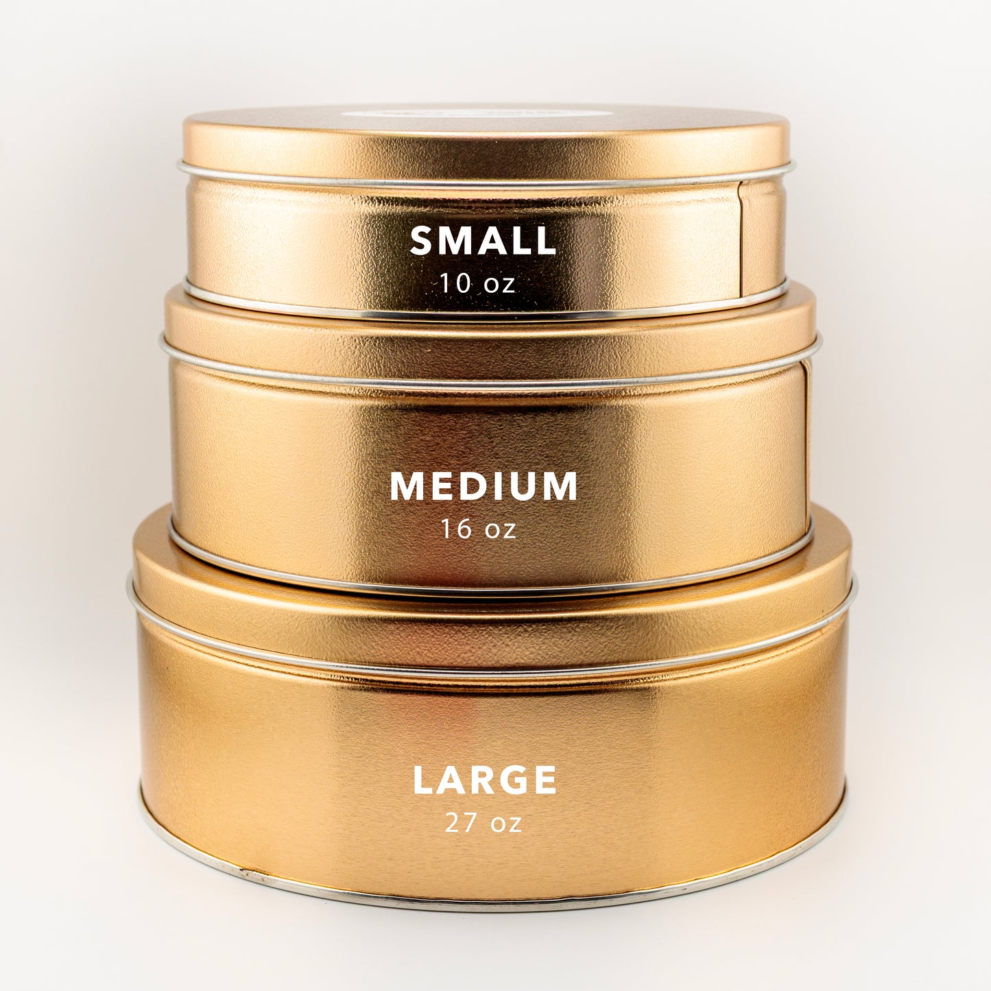 Three stacked gold metal containers with size labels on a light background