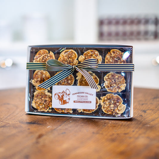 Box of Tennessee Valley Pecan Co. pecans on a wooden surface with a blurred background