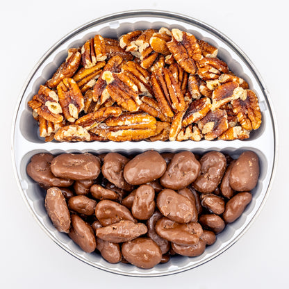 Toasted and milk chocolate pecans in a divided tin on white background.