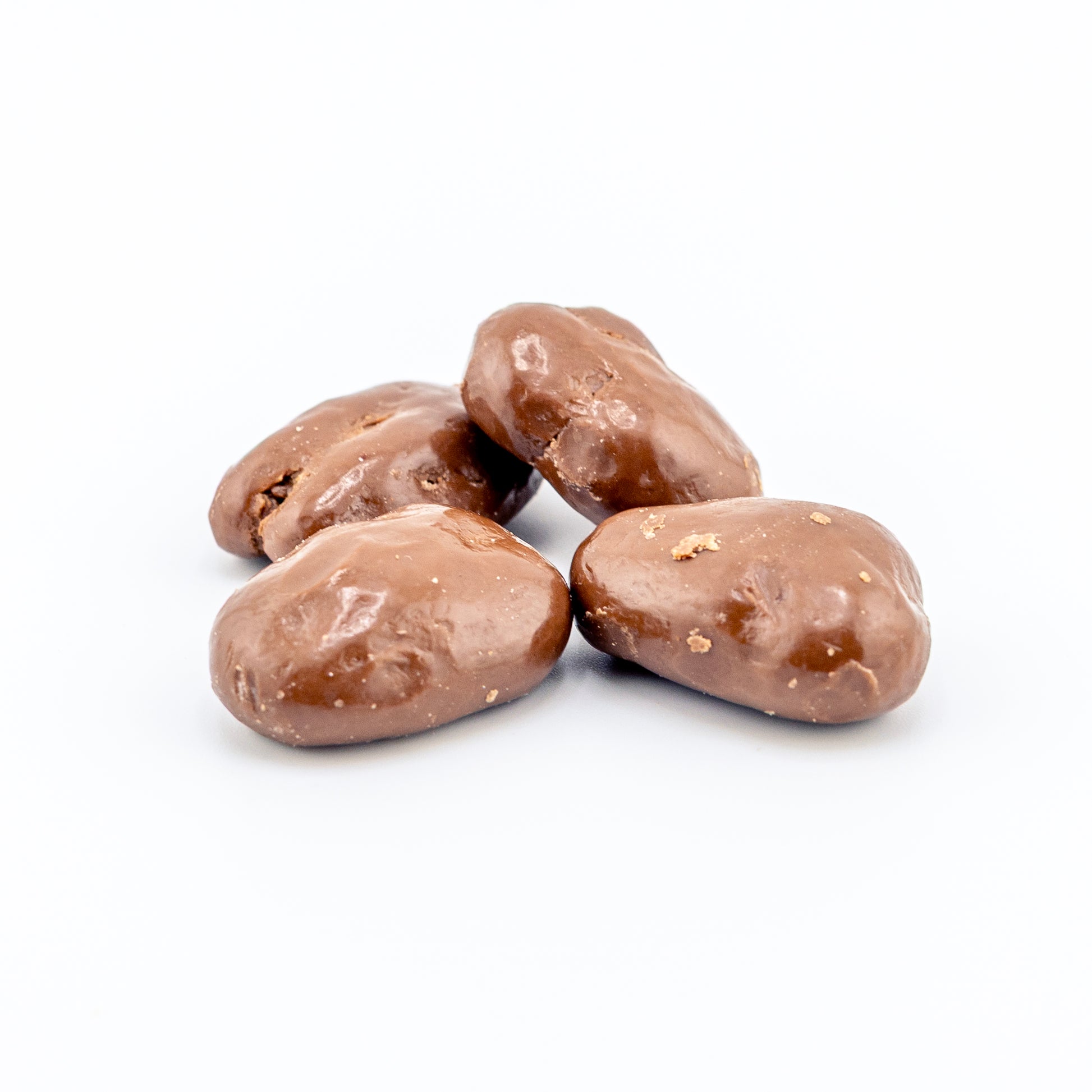 Milk Chocolate covered pecans on a white background