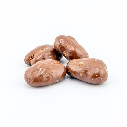 Milk Chocolate covered pecans on a white background