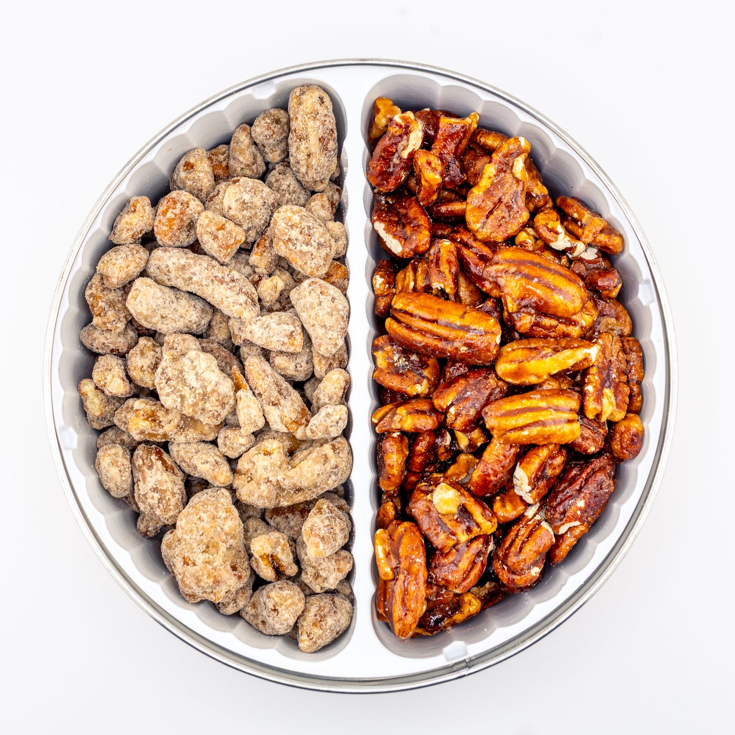 Praline and Honey Glazed pecans in a divided tin on white background.