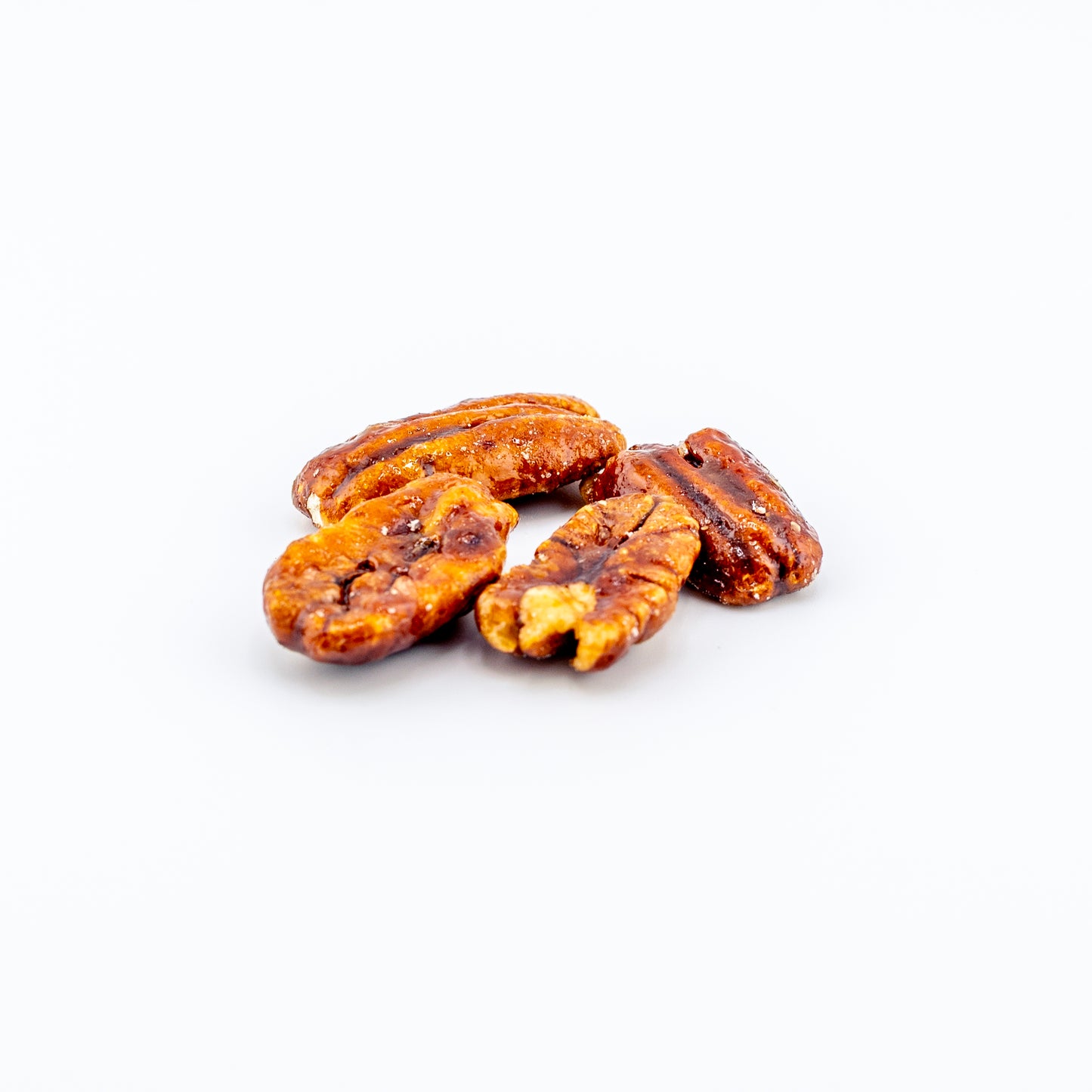 Honey-glazed pecans on a white background