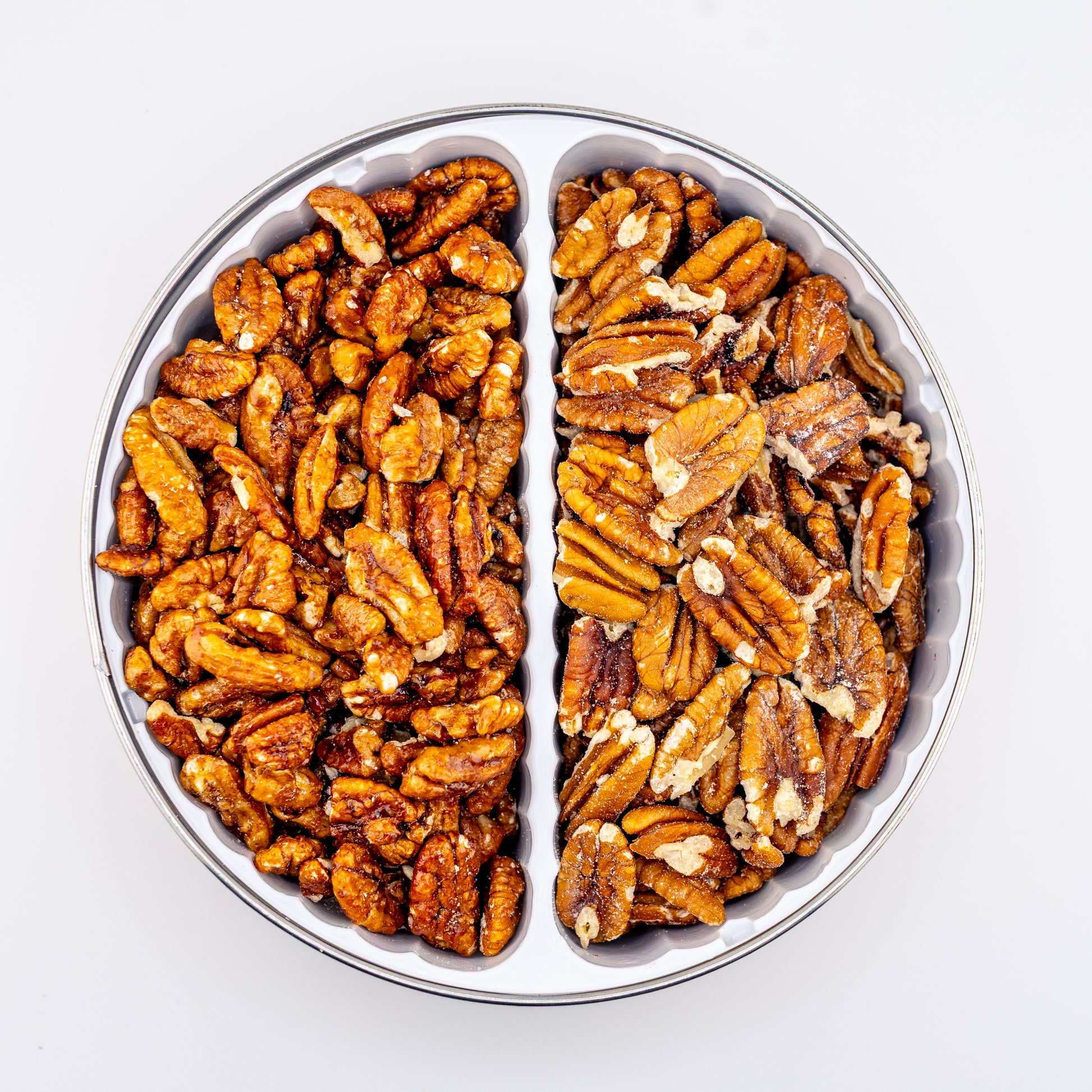 Toasted and Sweet Heat Pecans in a divided tin on white background.