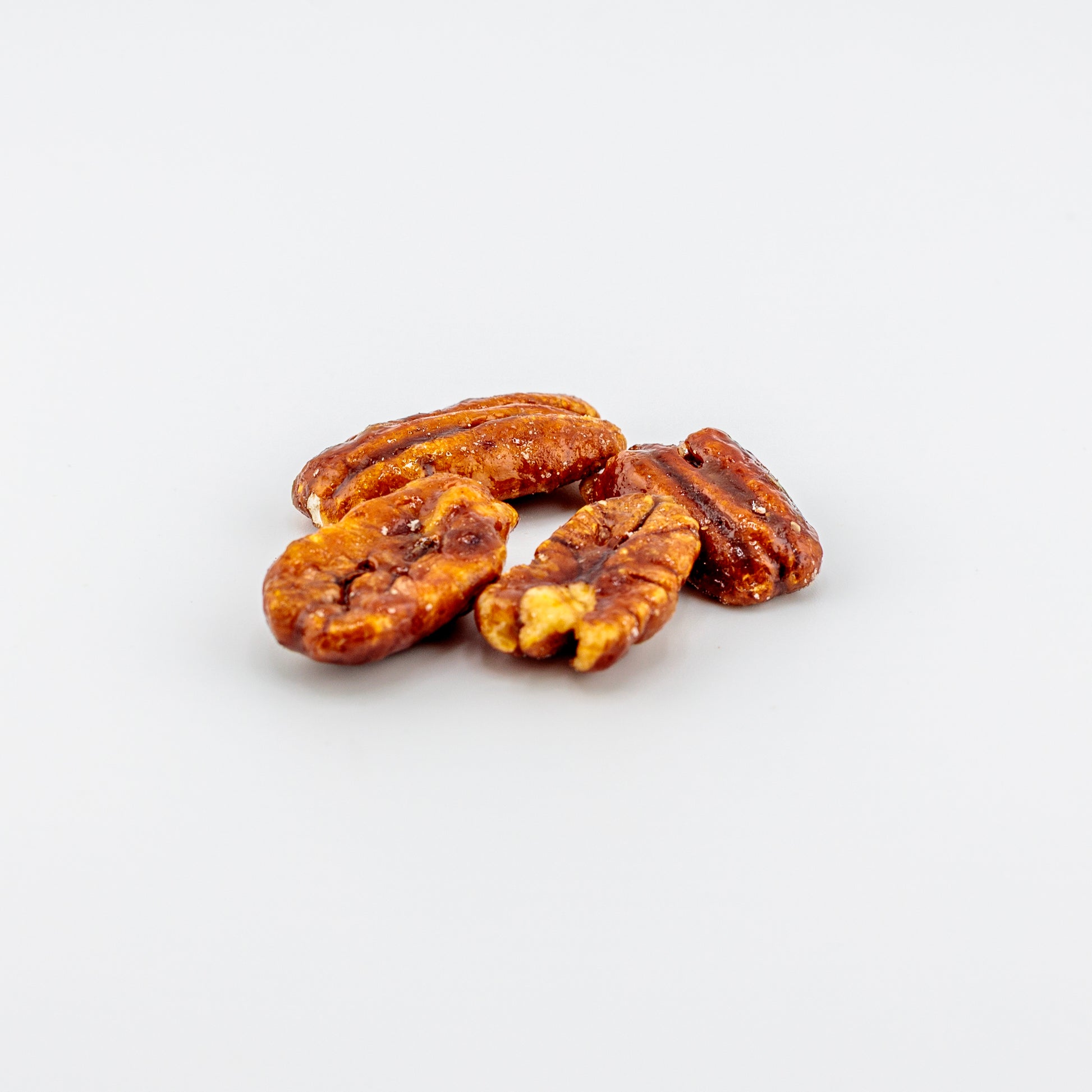 Honey glazed pecans on a white background