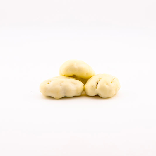 Three white chocolate pecans, arranged in a small pyramid on a seamless white background.