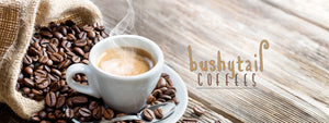 bushytail coffee logo next to steaming cup of coffee