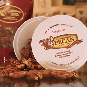 spicy pecans spilling out of white tub