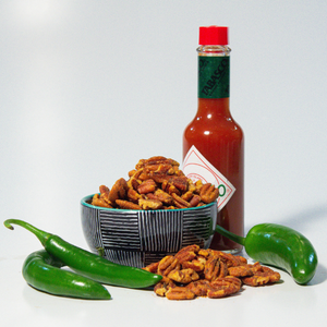 spicy pecans posed with Tabasco sauce and jalapeno peppers | gourmet pecans | Tennessee Valley Pecan Company